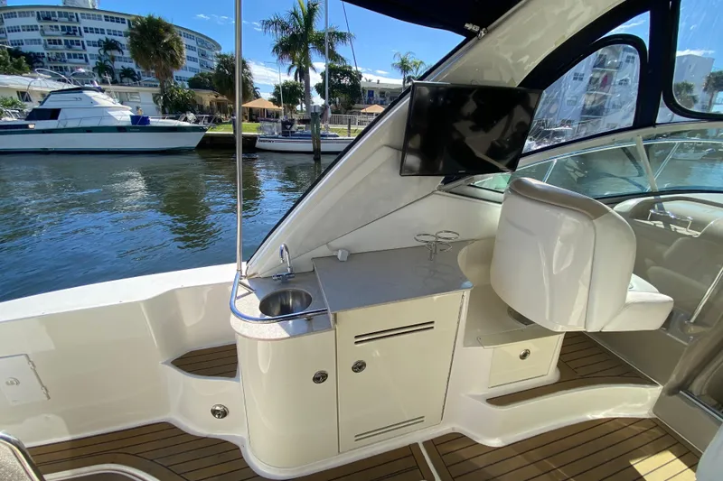 Slide: The Image of 2008 Sea Ray Sundancer 330 interior with sink, TV, and seating by the water. - 29