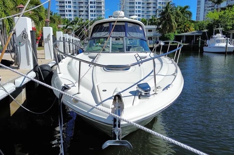Slide: The Image of 2008 Sea Ray Sundancer 330 docked in a marina, surrounded by lush greenery and buildings. - 6