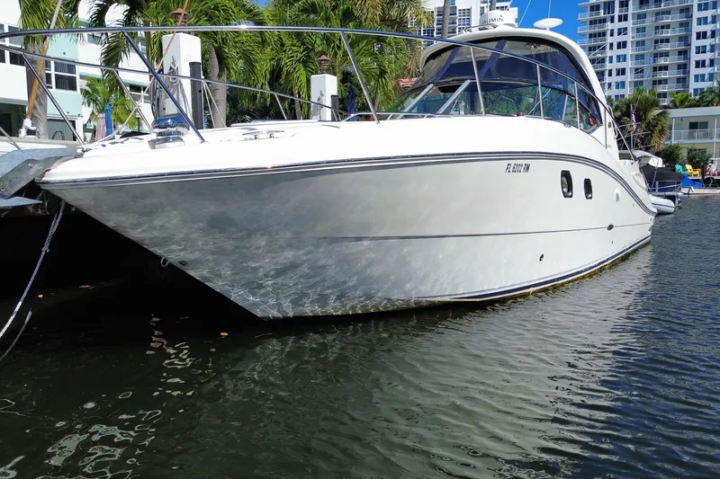 Slide: The Image of 2008 Sea Ray Sundancer 330 yacht docked in a marina, surrounded by palm trees and buildings. - 8