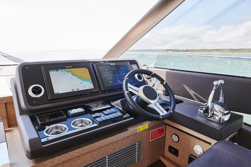 Slide: The Image of Prestige 590 yacht helm station with navigation screens and controls, 2020 model. - 12
