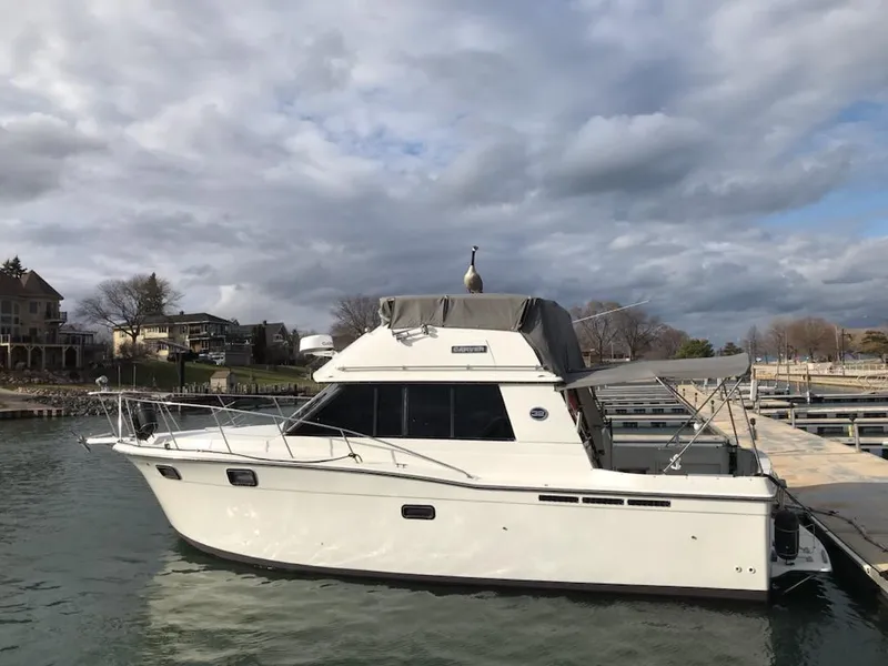Slide: The Image of 1989 Carver 32 Convertible yacht docked under cloudy skies. - 2