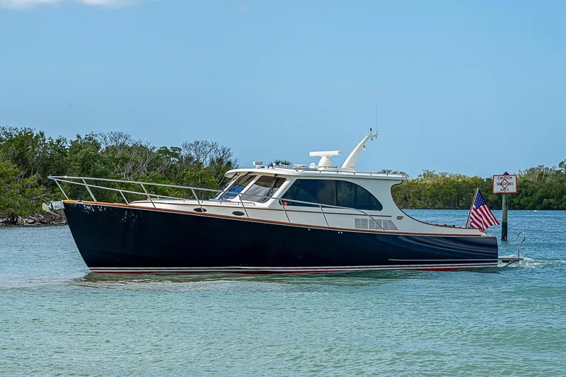 Slide: The Image of 2021 Hinckley Talaria 43 yacht cruising in clear waters with American flag. - 11