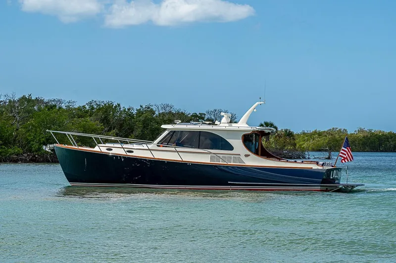 Slide: The Image of 2021 Hinckley Talaria 43 yacht cruising on a serene waterway with lush greenery. - 14