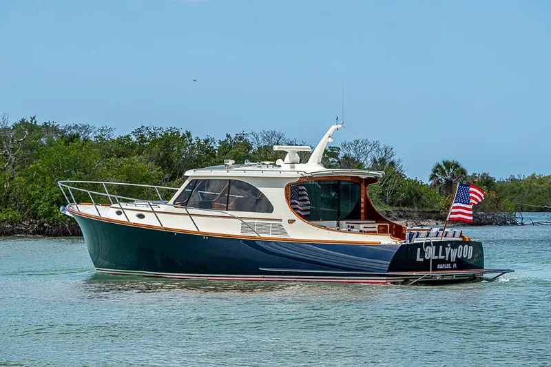 Slide: The Image of 2021 Hinckley Talaria 43 yacht cruising in scenic waters with American flag. - 16