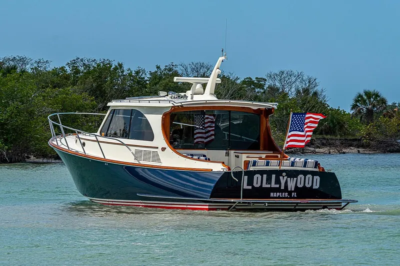 Slide: The Image of 2021 Hinckley Talaria 43 yacht cruising in scenic waters with American flags. - 17
