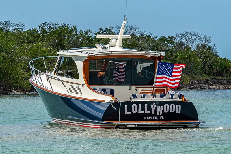Slide: The Image of 2021 Hinckley Talaria 43 yacht cruising in clear waters, American flag displayed. - 18