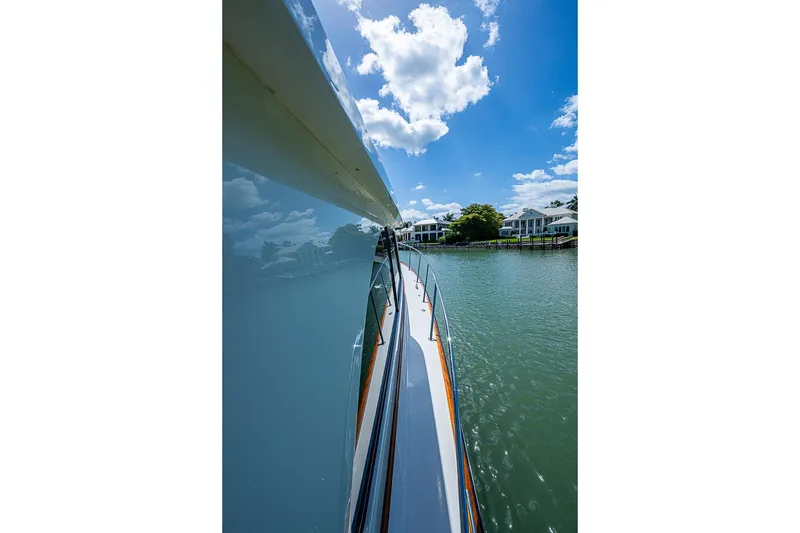 Slide: The Image of Hinckley Talaria 43 yacht cruising on a sunny day, reflecting blue sky and clouds. - 21