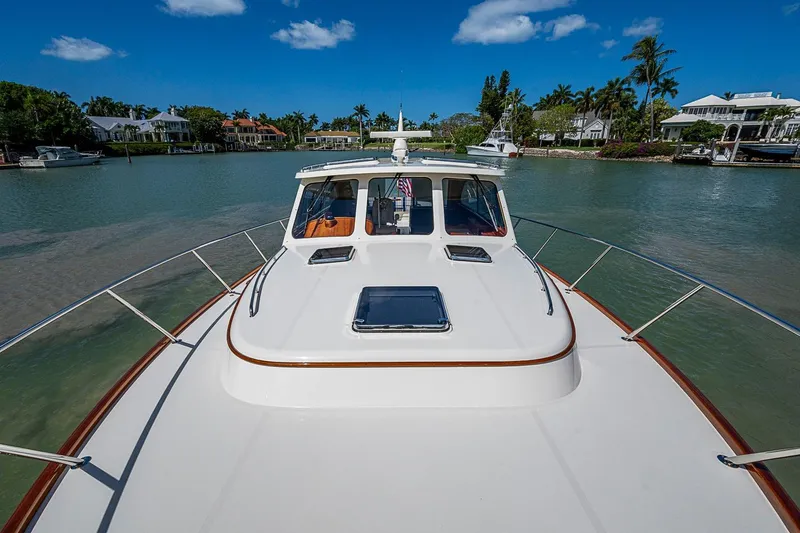 Slide: The Image of 2021 Hinckley Talaria 43 yacht cruising in a scenic waterfront area. - 24