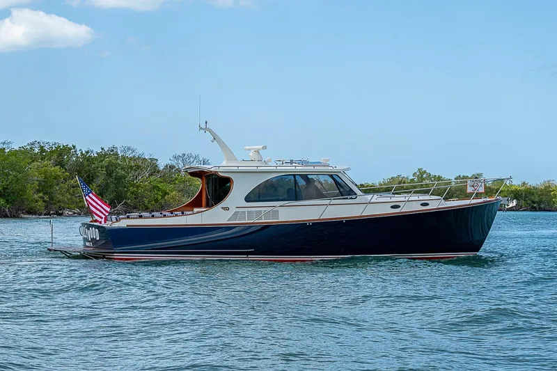 Slide: The Image of 2021 Hinckley Talaria 43 yacht cruising on a serene waterway with lush greenery. - 3