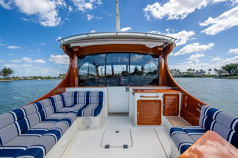 Slide: The Image of 2021 Hinckley Talaria 43 yacht interior with striped seating, wooden accents, and scenic water view. - 32