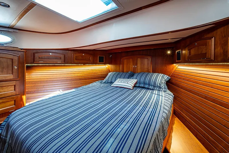Slide: The Image of Luxurious cabin interior of 2021 Hinckley Talaria 43 yacht with wood paneling and striped bedding. - 35