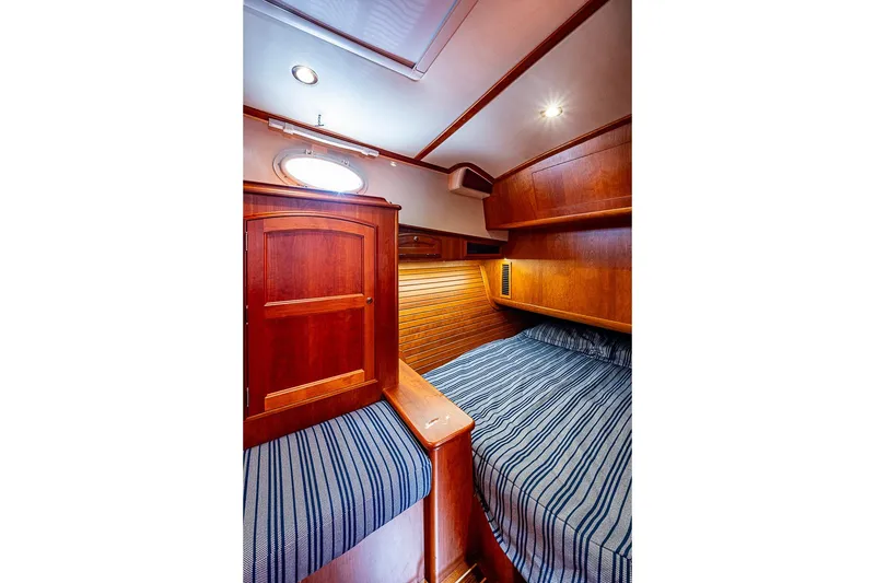 Slide: The Image of Luxurious cabin interior of 2021 Hinckley Talaria 43 yacht with wooden finishes and striped bedding. - 42