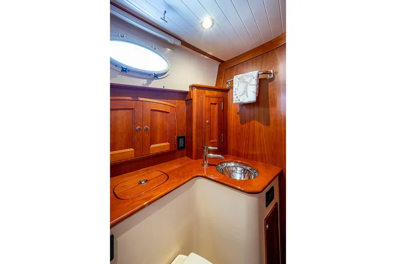 Slide: The Image of Luxurious wooden interior of 2021 Hinckley Talaria 43 yacht bathroom with sink and cabinets. - 48