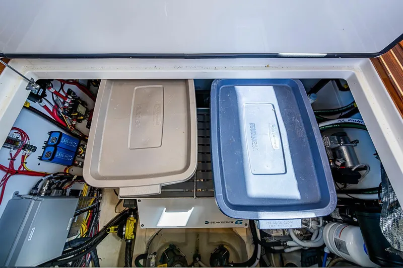 Slide: The Image of Engine compartment of 2021 Hinckley Talaria 43 with storage bins and electrical components. - 52