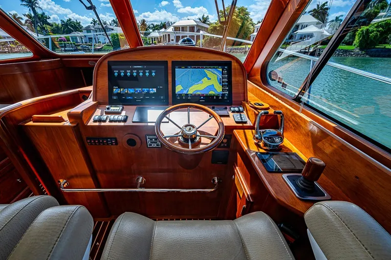 Slide: The Image of Helm of 2021 Hinckley Talaria 43 yacht with navigation screens and wooden steering wheel. - 62
