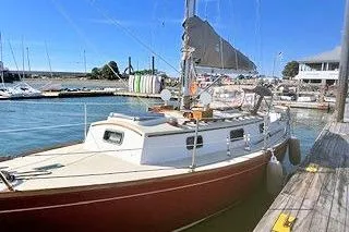 Slide: The Image of 1987 Morris Linda sailboat docked at a marina under clear blue skies. - 14