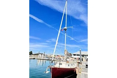Slide: The Image of 1987 Morris Linda sailboat docked at a marina under a clear blue sky. - 2