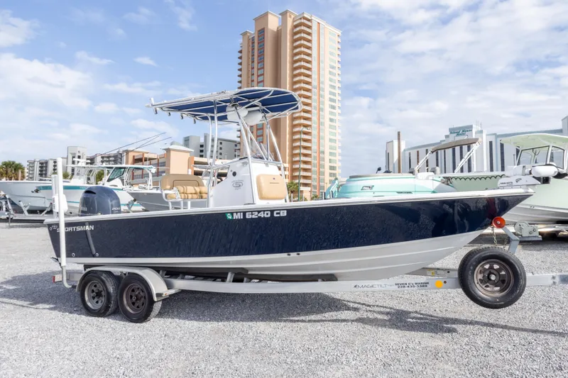 Slide: The Image of 2021 Sportsman Masters 227 Bay Boat on trailer, urban backdrop, clear sky. - 2