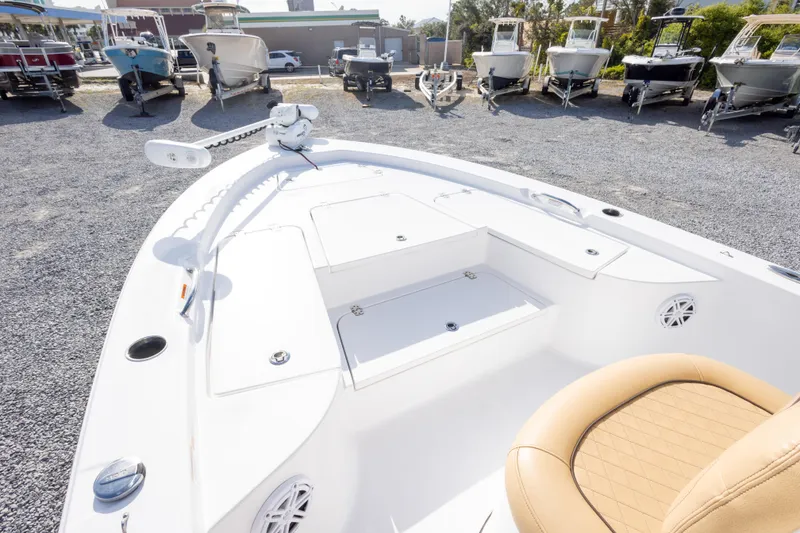 Slide: The Image of 2021 Sportsman Masters 227 Bay Boat interior with tan seating, docked among other boats. - 25