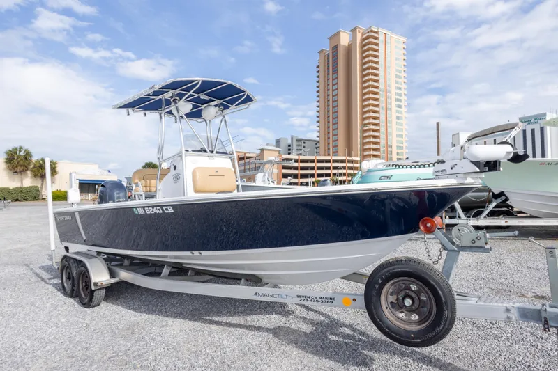 Slide: The Image of 2021 Sportsman Masters 227 Bay Boat on trailer, cityscape background, clear sky. - 3