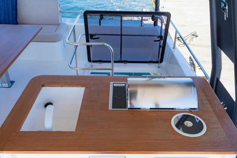 Slide: The Image of Outdoor kitchen area on 2024 Fountaine Pajot MY5 yacht, featuring a sink and grill. - 14