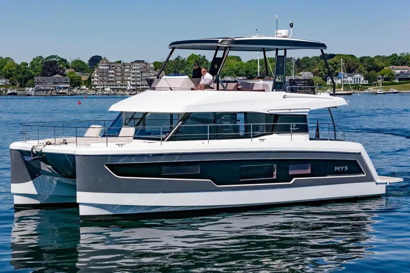 Slide: The Image of 2024 Fountaine Pajot MY5 yacht cruising on a serene lake with scenic shoreline. - 66