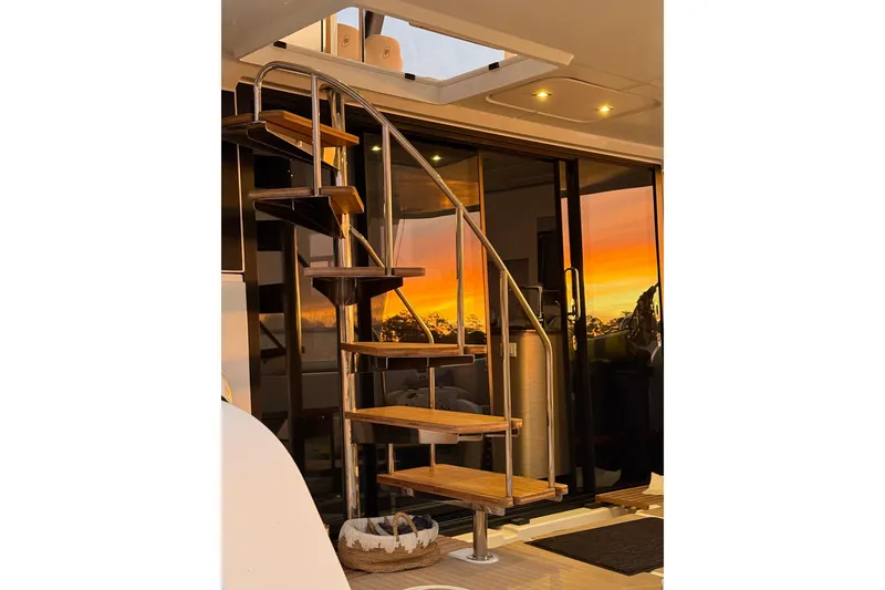 Slide: The Image of Spiral staircase on 2024 Fountaine Pajot MY5 yacht with sunset reflection on glass doors. - 11