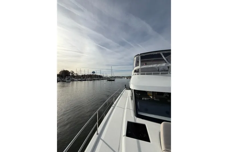 Slide: The Image of 2024 Fountaine Pajot MY5 yacht docked in a serene marina under a cloudy sky. - 12