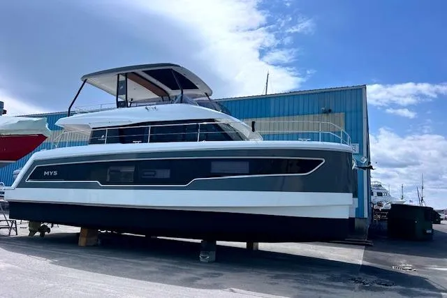 Slide: The Image of 2024 Fountaine Pajot MY5 yacht docked at a marina under a blue sky. - 2