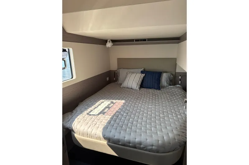 Slide: The Image of Cozy bedroom interior of 2024 Fountaine Pajot MY5 yacht with plush bedding and window view. - 24