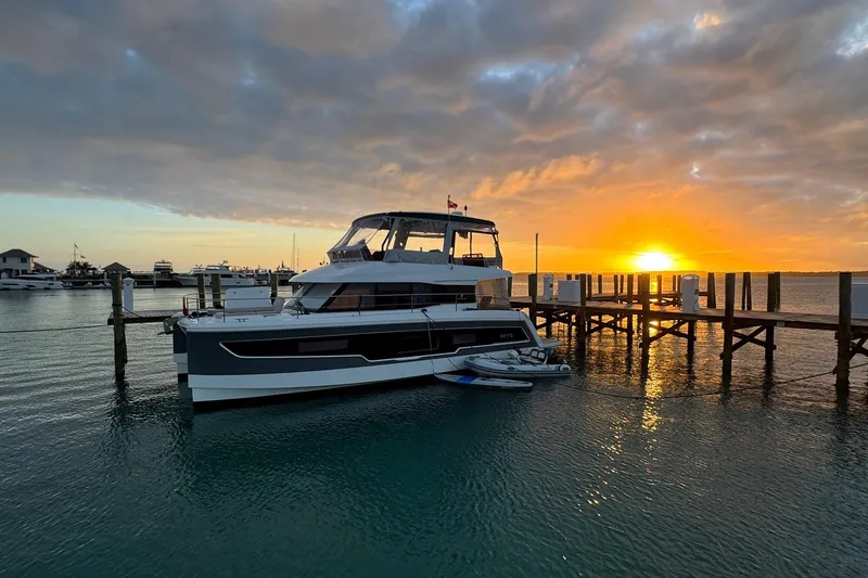Slide: The Image of 2024 Fountaine Pajot MY5 yacht docked at sunset, serene waterfront view. - 5