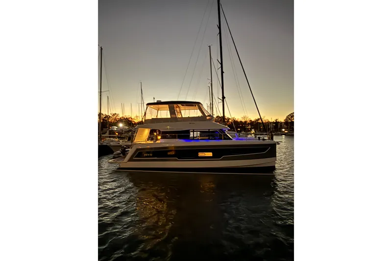 Slide: The Image of 2024 Fountaine Pajot MY5 yacht illuminated at sunset in a marina setting. - 9