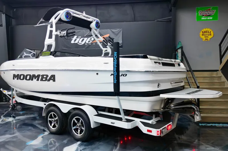 Slide: The Image of 2019 Moomba Mojo boat on trailer in showroom, featuring sleek design and vibrant lighting. - 8