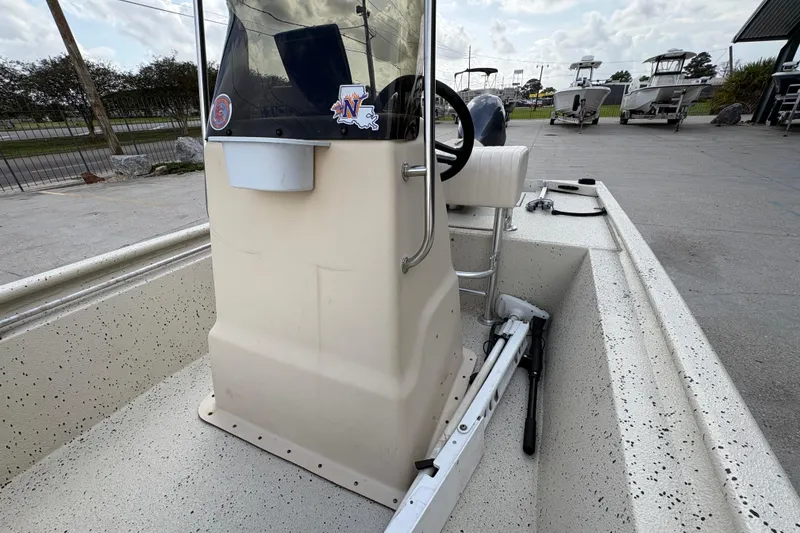Slide: The Image of 2012 Xpress 1650VJF boat console with steering wheel and seating, parked outdoors. - 12
