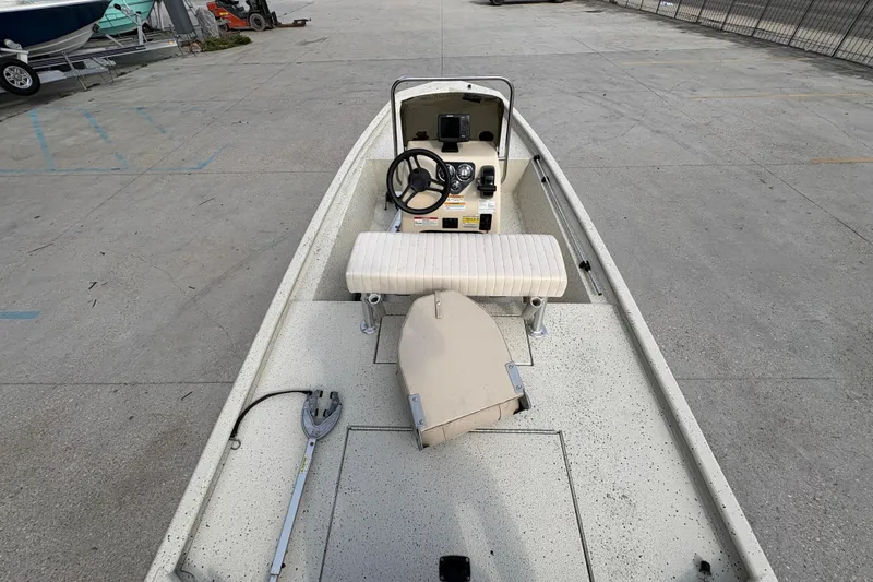 Slide: The Image of 2012 Xpress 1650VJF boat interior with steering wheel and seating, parked on concrete. - 19