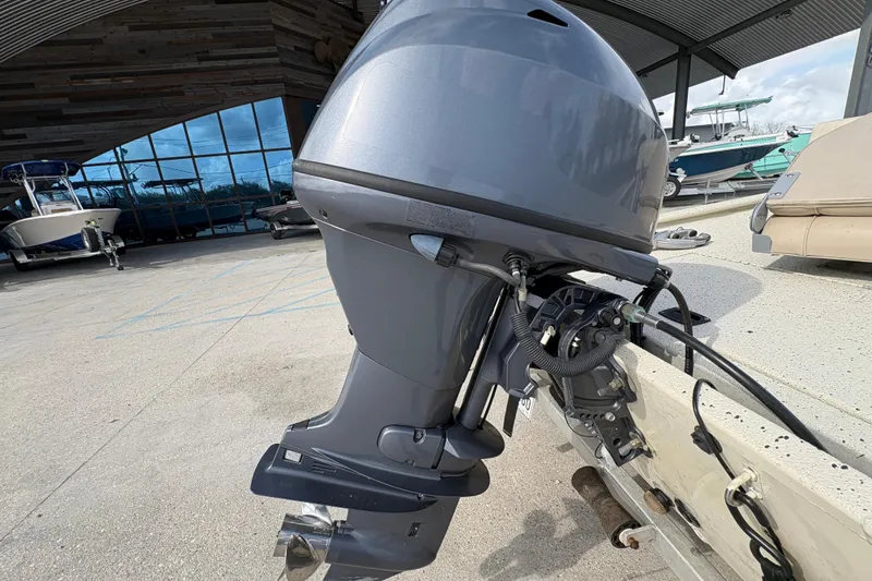 Slide: The Image of Outboard motor on a 2012 Xpress 1650VJF boat, displayed at a marina. - 20