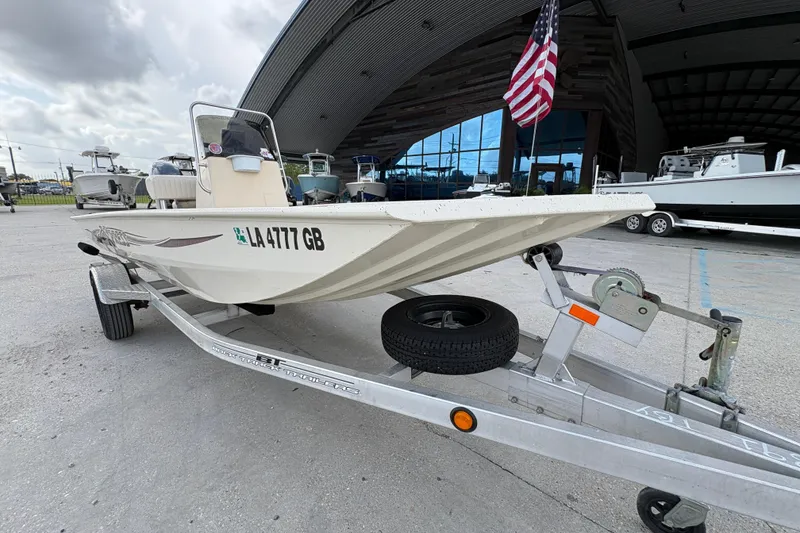 Slide: The Image of 2012 Xpress 1650VJF boat on trailer, parked outside a large building. - 9