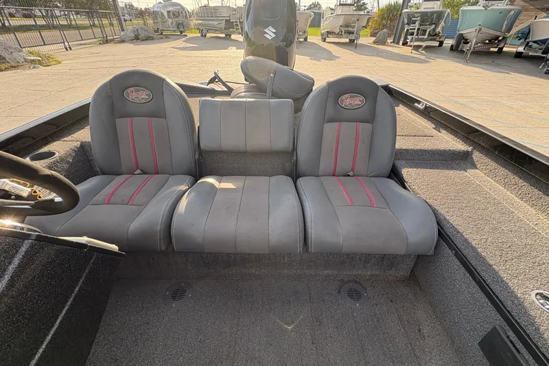 Slide: The Image of 2016 Ranger RT188 boat interior with gray and red seats, parked outdoors. - 18