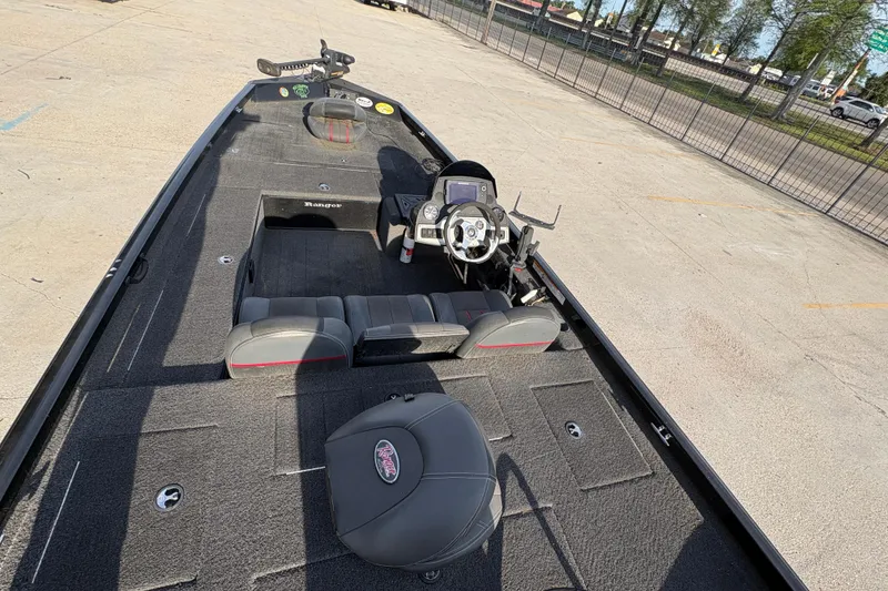 Slide: The Image of 2016 Ranger RT188 boat interior with steering console and seating, parked on concrete. - 19