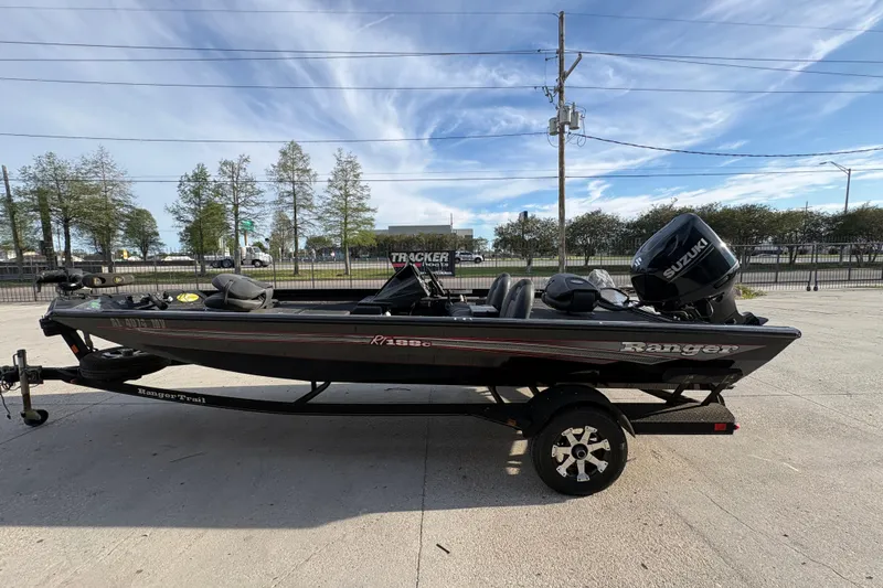 Slide: The Image of 2016 Ranger RT188 boat with Suzuki motor on trailer, parked outdoors. - 7