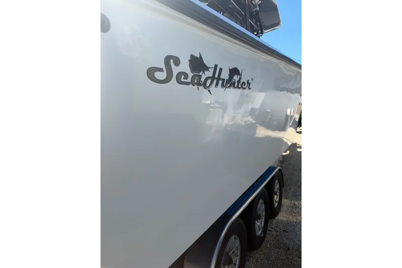 Slide: The Image of 2016 SeaHunter 35 Tournament boat side view with logo and triple-axle trailer. - 12