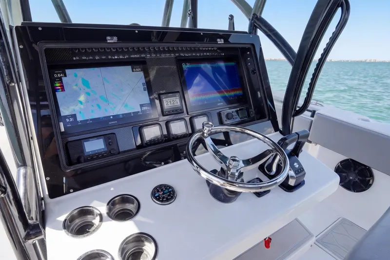 Slide: The Image of 2016 SeaHunter 35 Tournament boat dashboard with navigation screens and steering wheel. - 15