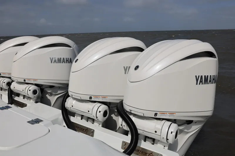 Slide: The Image of Four Yamaha outboard motors on a 2024 Freeman 38 boat, ocean background. - 30