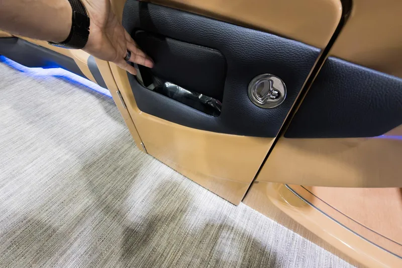 Slide: The Image of Hand opening storage compartment on 2026 Godfrey Monaco 255 Single Flip Lounge boat. - 16