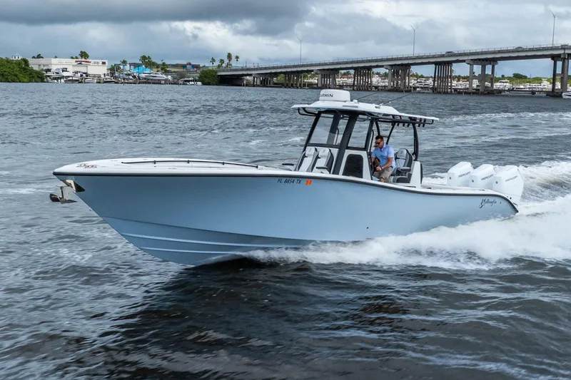 The Image of 2025 Yellowfin 36 Offshore boat cruising on water near a bridge under cloudy skies. - 0