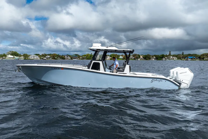 Slide: The Image of 2025 Yellowfin 36 Offshore boat cruising on a lake under cloudy skies. - 17