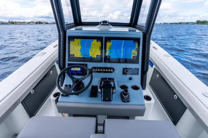 Slide: The Image of 2025 Yellowfin 36 Offshore boat cockpit with advanced navigation displays on open water. - 22