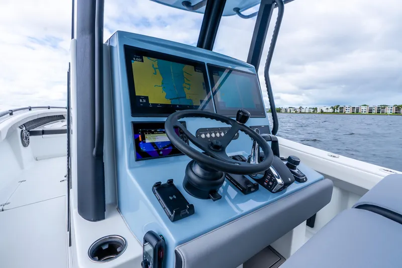 Slide: The Image of 2025 Yellowfin 36 Offshore boat dashboard with navigation screens and steering wheel. - 24