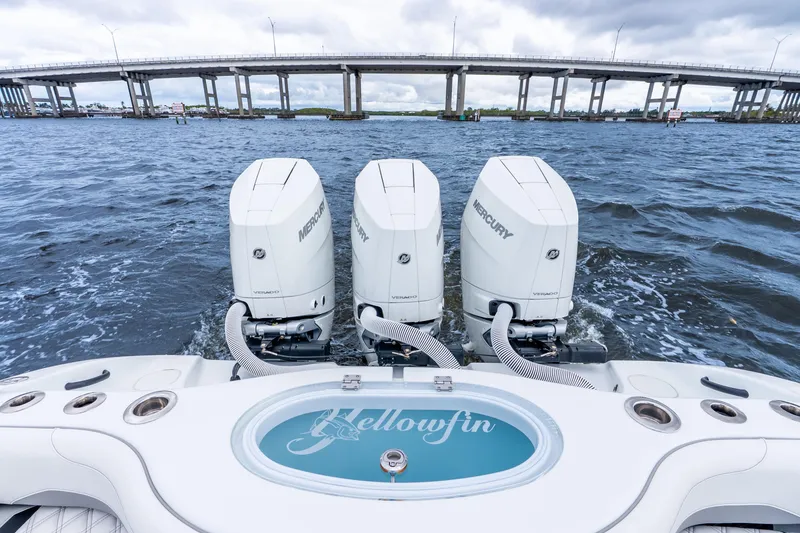 Slide: The Image of 2025 Yellowfin 36 Offshore boat with triple Mercury engines on water near a bridge. - 37