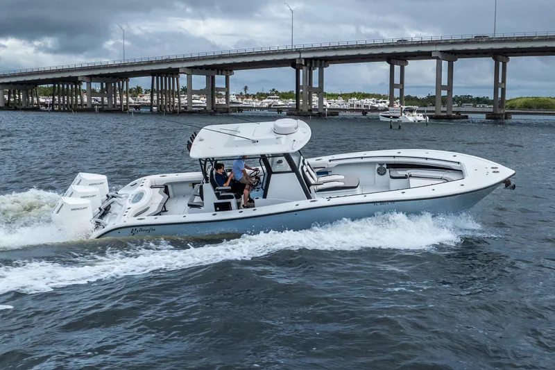 Slide: The Image of 2025 Yellowfin 36 Offshore boat cruising under a bridge on a cloudy day. - 6